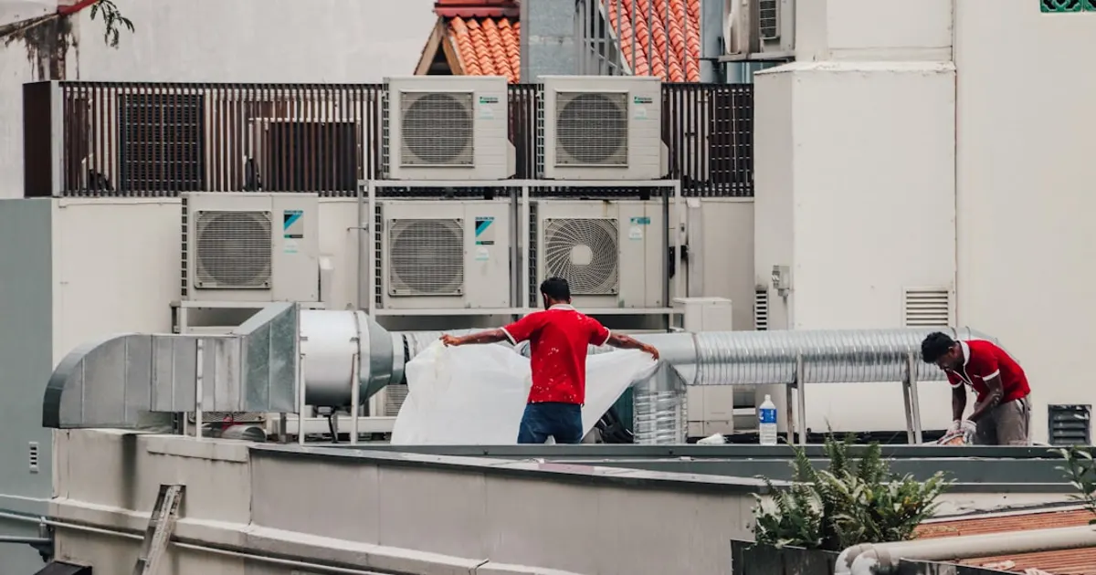 A couple of men standing on top of a roof