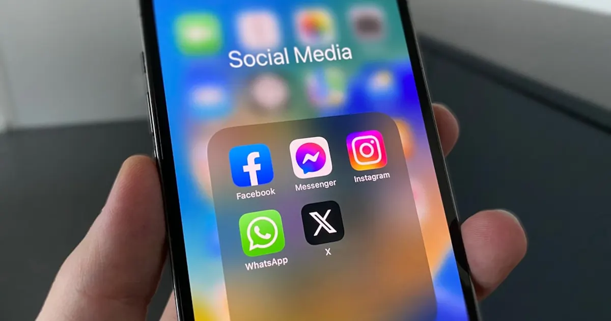 A person holding a cell phone with social media on the screen